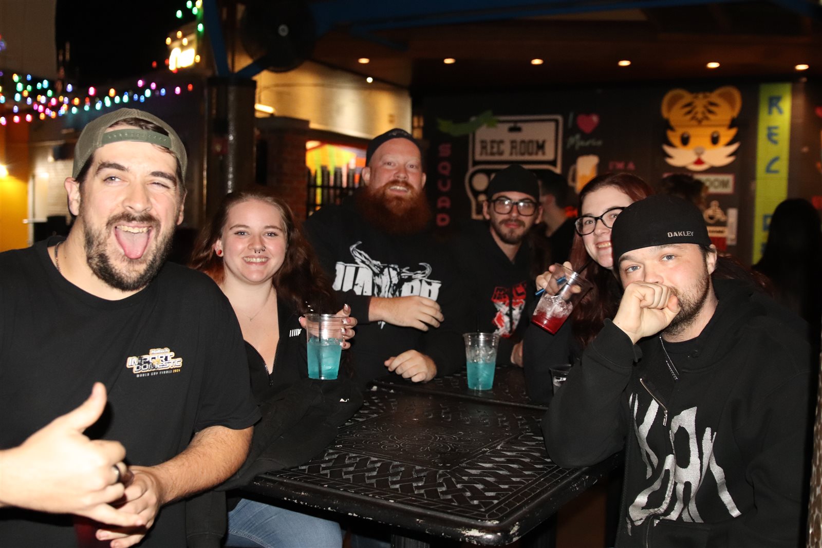 Friends with cocktails on a bar patio at night